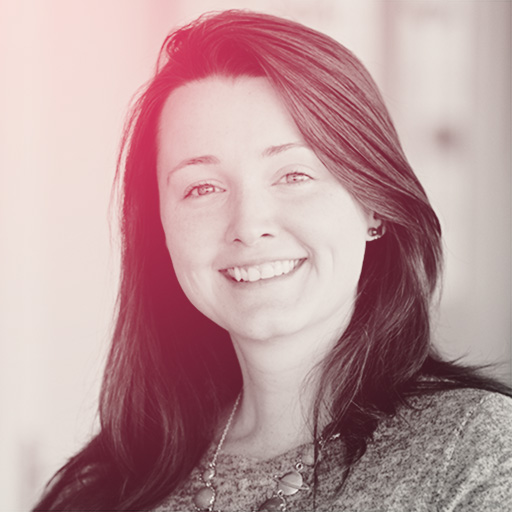 A portrait of Erica; a smiling woman in her thirties with brown hair and a pale skin tone.